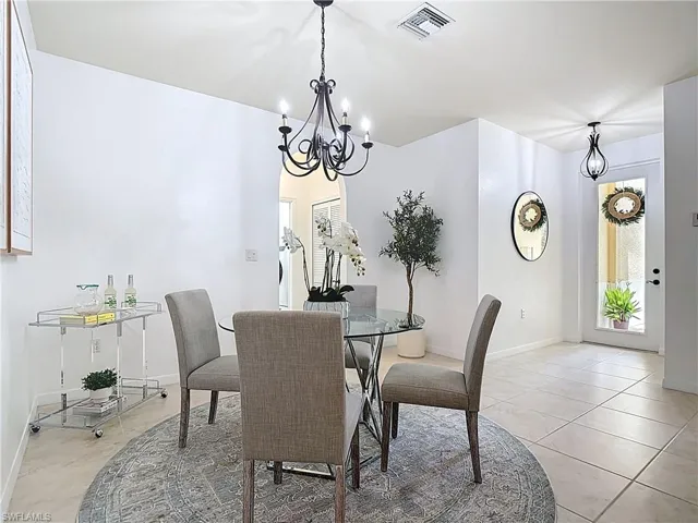 Dining area with a chandelier and light tile patterned flooring