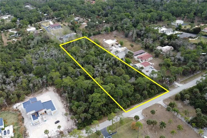 Aerial view of property's location featuring property parcel outlined and a heavily wooded area