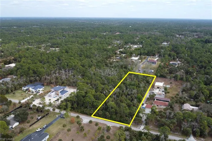 Aerial view of property's location with property parcel outlined and a forest