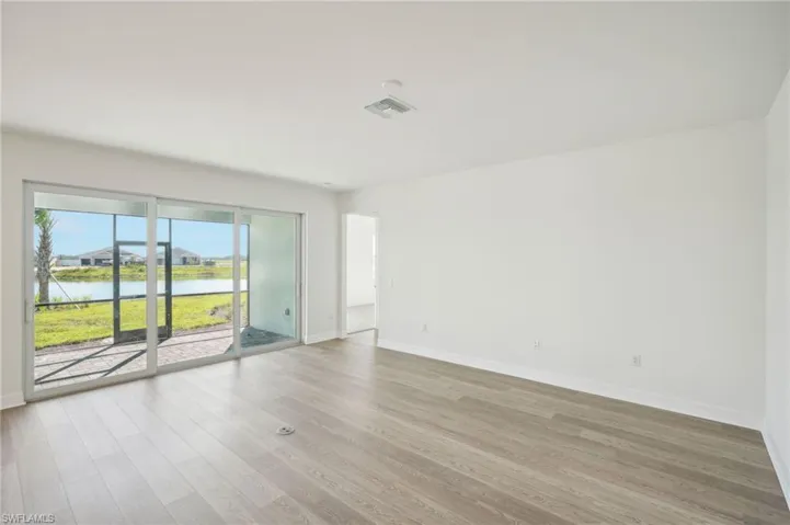 Unfurnished room featuring a water view and hardwood / wood-style floors