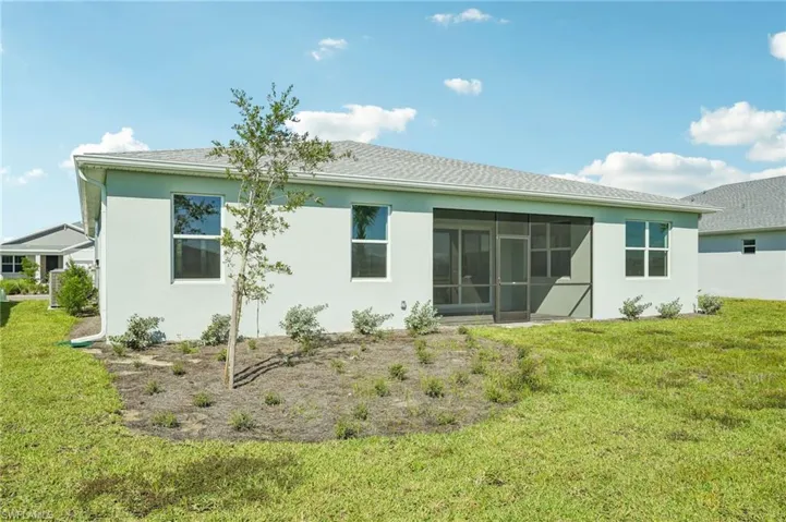 Rear view of property with a sunroom and a yard