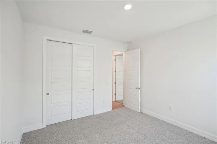 Unfurnished bedroom with a closet and carpet floors