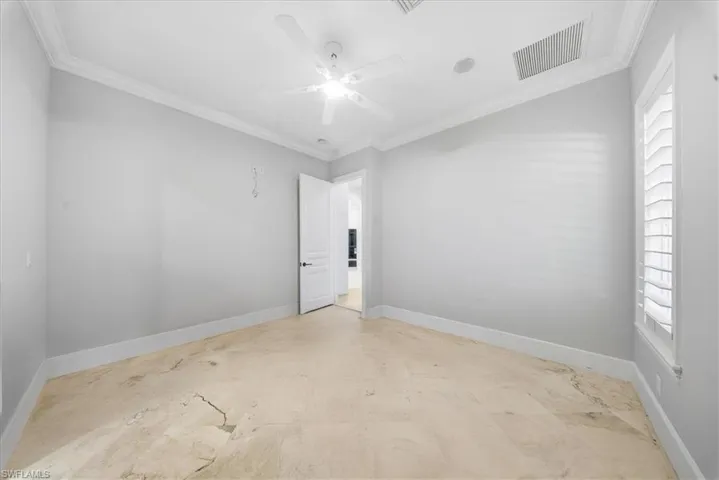 Empty room featuring ornamental molding and ceiling fan