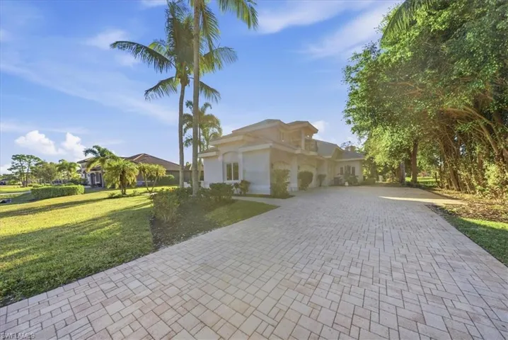 Mediterranean / spanish home with driveway, a front yard, stucco siding, and a garage