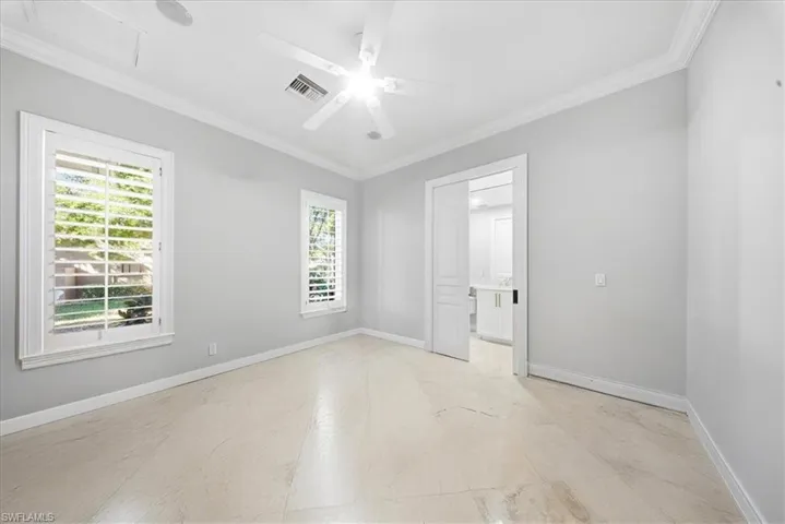 Spare room with crown molding and a ceiling fan