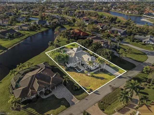 Aerial view of residential area with a large body of water and property boundaries highlighted