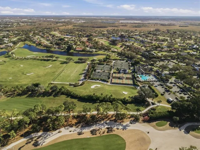 Aerial view of property's location featuring a local golf course, a large body of water, and nearby suburban area