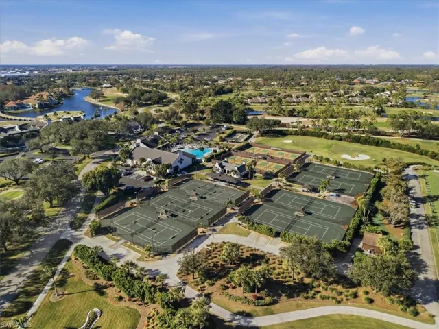 View of property location featuring a large body of water, a golf course, and nearby suburban area