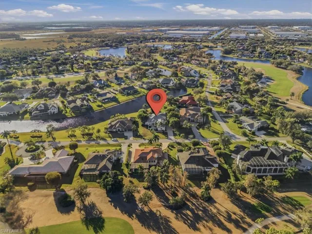 Aerial view of property and surrounding area with a large body of water and nearby suburban area