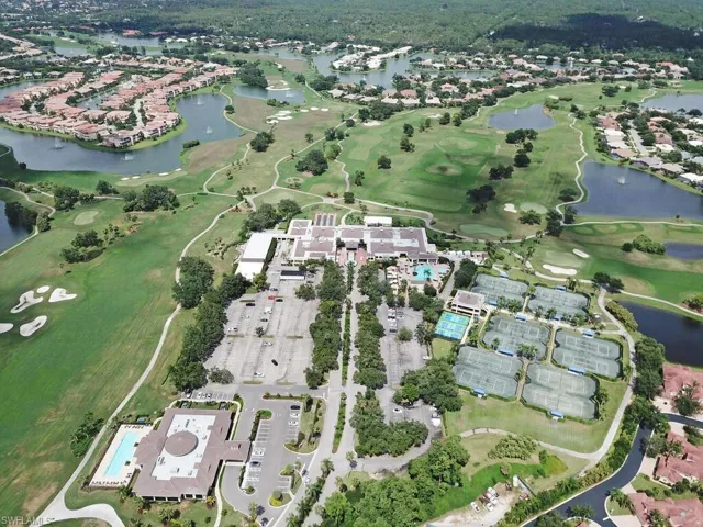 Aerial view of property and surrounding area with a large body of water and a golf course