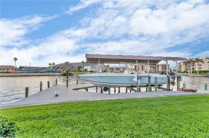 Dock area with a yard and a water view