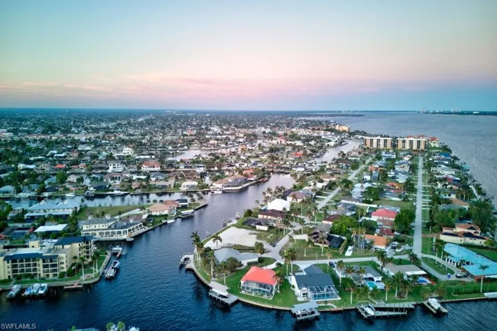 Aerial view at dusk featuring a water view