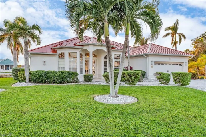 Mediterranean / spanish-style home featuring a front lawn and a garage
