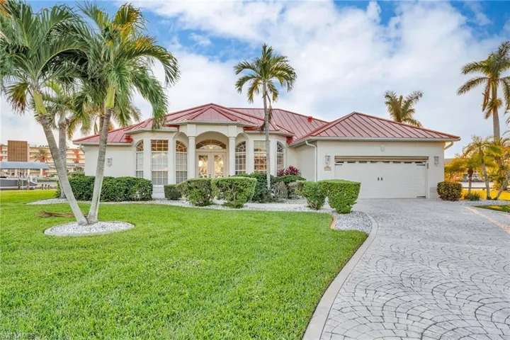 Mediterranean / spanish-style home with a garage and a front lawn