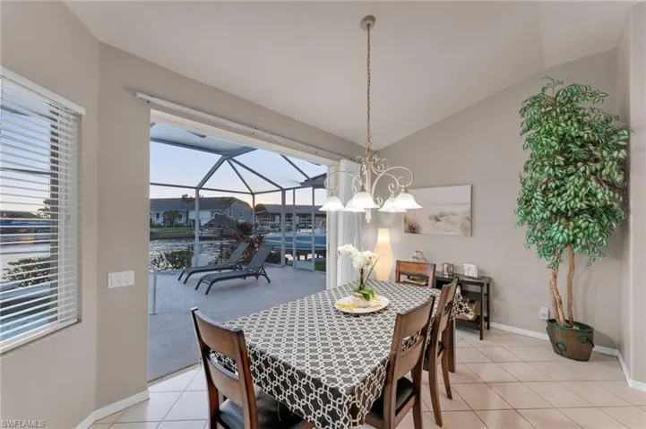 Tiled dining area featuring a healthy amount of sunlight and vaulted ceiling