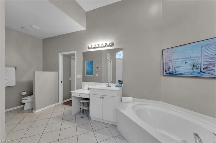 Bathroom with a bathing tub, tile patterned flooring, vanity, and toilet