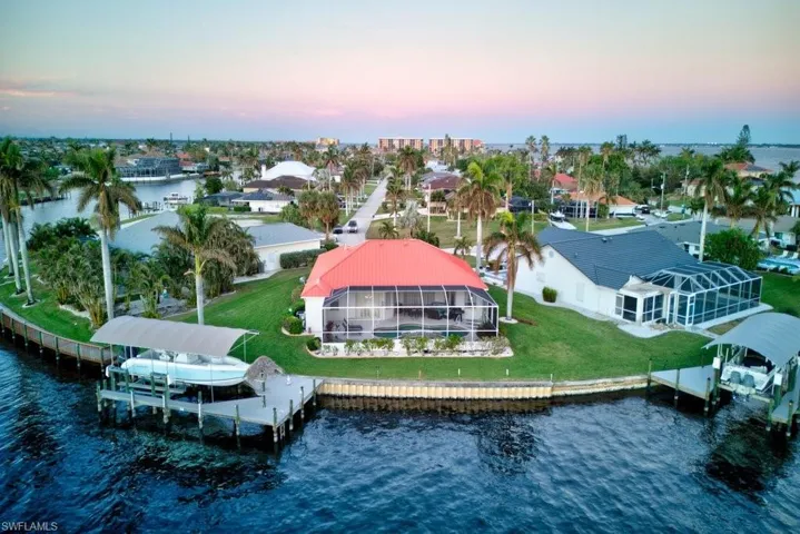 Aerial view at dusk featuring a water view