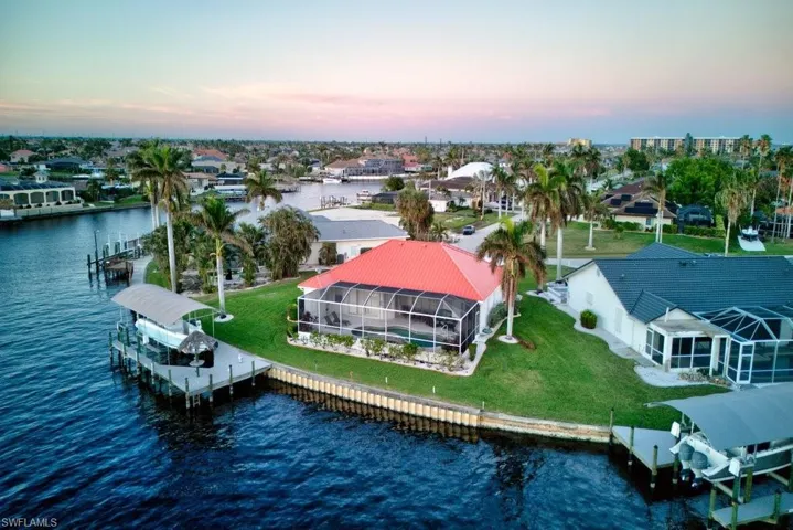 Aerial view at dusk featuring a water view