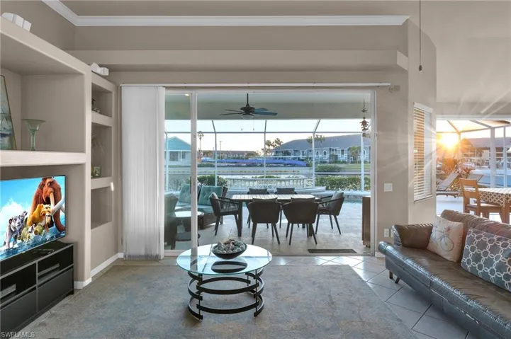 Tiled living room featuring ceiling fan and ornamental molding