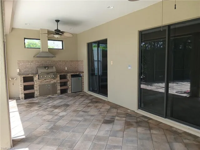 View of patio / terrace featuring exterior kitchen, ceiling fan, and a grill