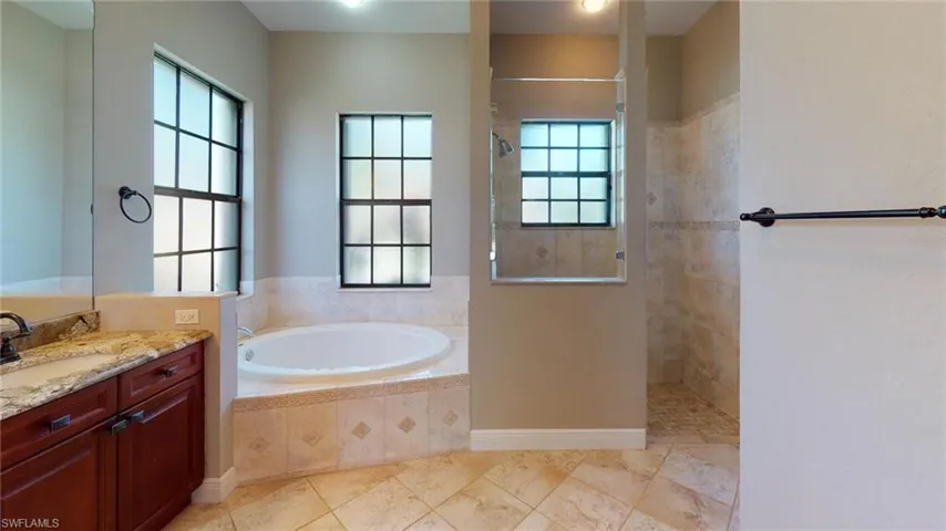 Bathroom featuring separate shower and tub and vanity