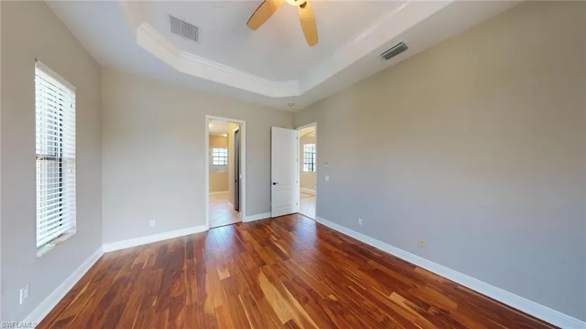 Unfurnished room with a healthy amount of sunlight, ceiling fan, ornamental molding, and hardwood / wood-style flooring