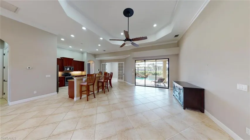 Kitchen featuring a kitchen bar, a center island, stainless steel appliances, crown molding, and ceiling fan