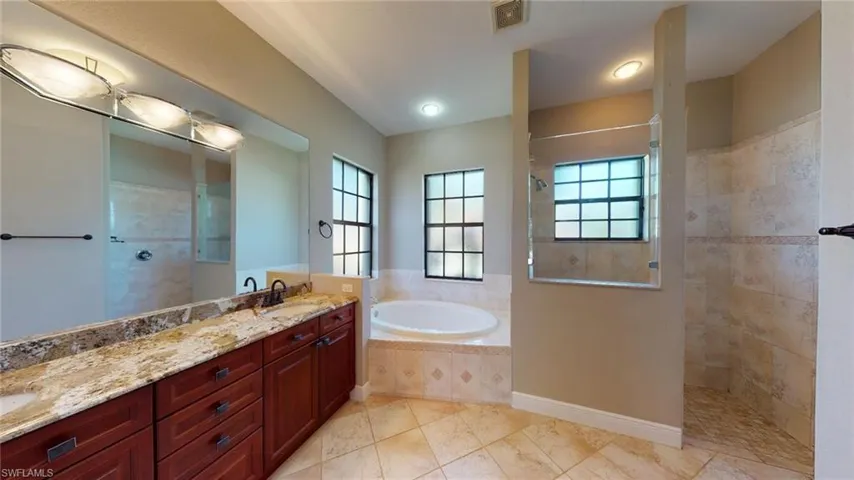 Bathroom featuring vanity and plus walk in shower
