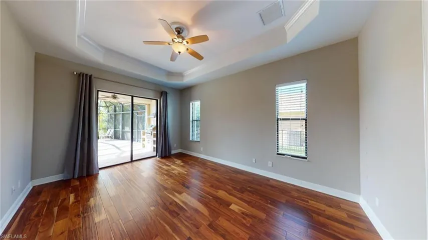 Spare room with crown molding, a raised ceiling, ceiling fan, and dark hardwood / wood-style floors