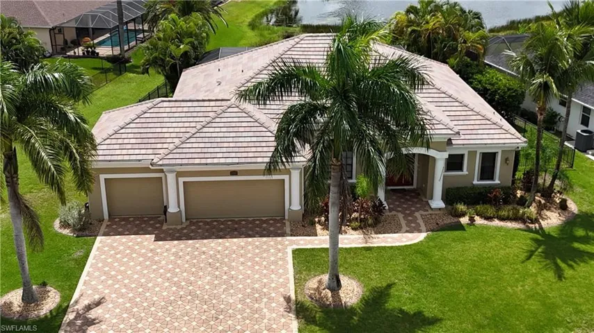 View of front of house featuring a garage, a water view, and a front lawn