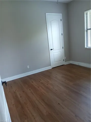 Unfurnished room featuring dark hardwood / wood-style floors