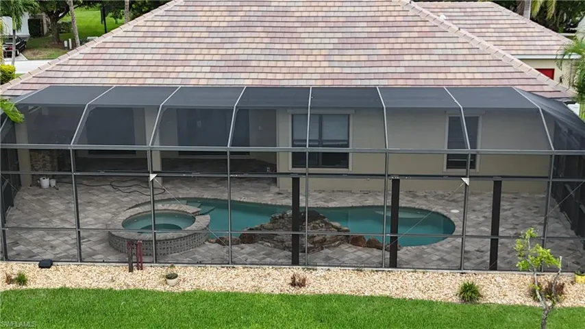 View of swimming pool featuring a patio area, an in ground hot tub, and a lanai