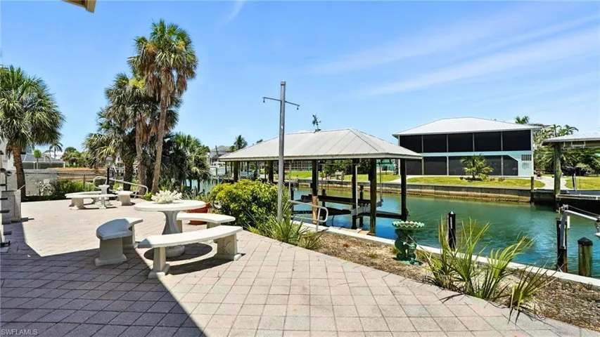 View of patio with a water view and boat lift - Virtually Edited Image