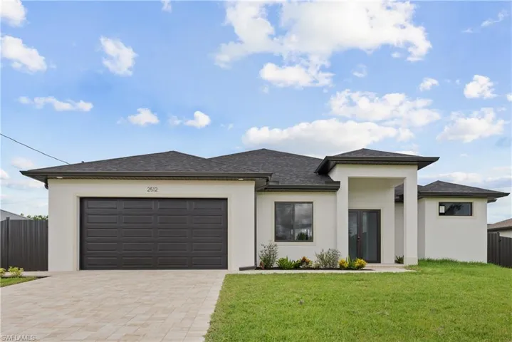 Prairie-style home featuring a front lawn and a garage