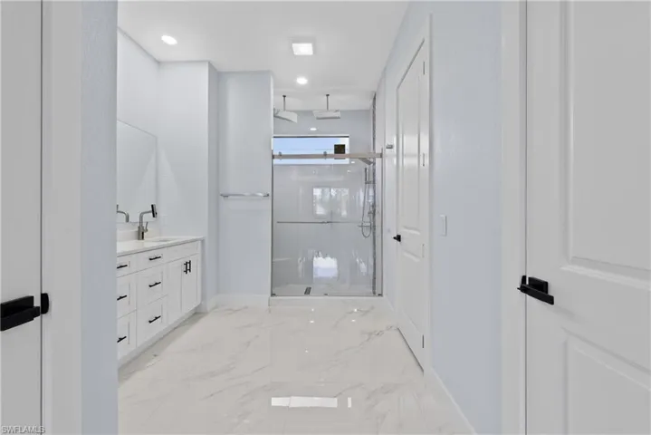 Bathroom featuring tiled shower, tile floors, and vanity