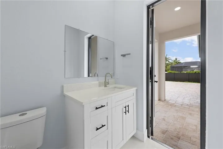 Bathroom with oversized vanity, toilet, and tile floors