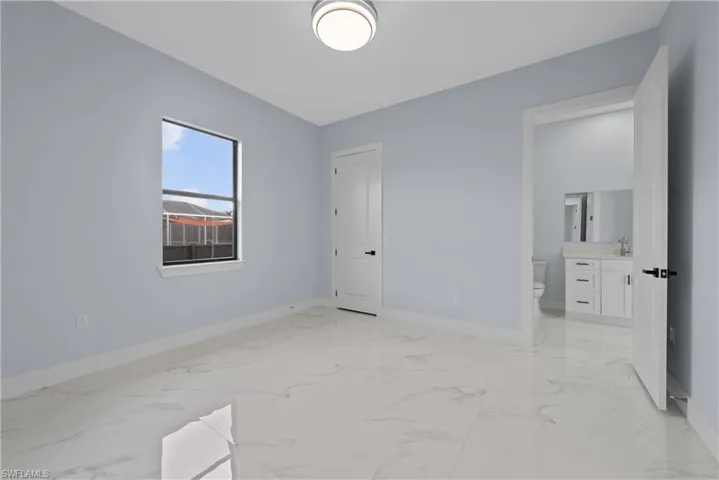 Unfurnished bedroom with sink and light tile flooring