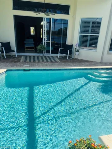 View of swimming pool with a patio area and ceiling fan