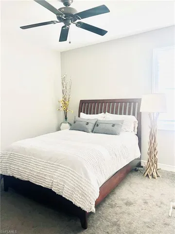 Carpeted bedroom featuring ceiling fan
