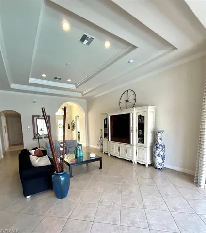 Tiled living room with a raised ceiling and crown molding