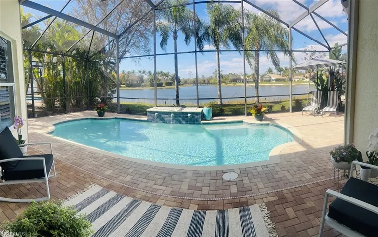 View of swimming pool featuring a water view, a patio, and glass enclosure