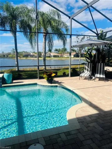 View of pool with glass enclosure and a patio area