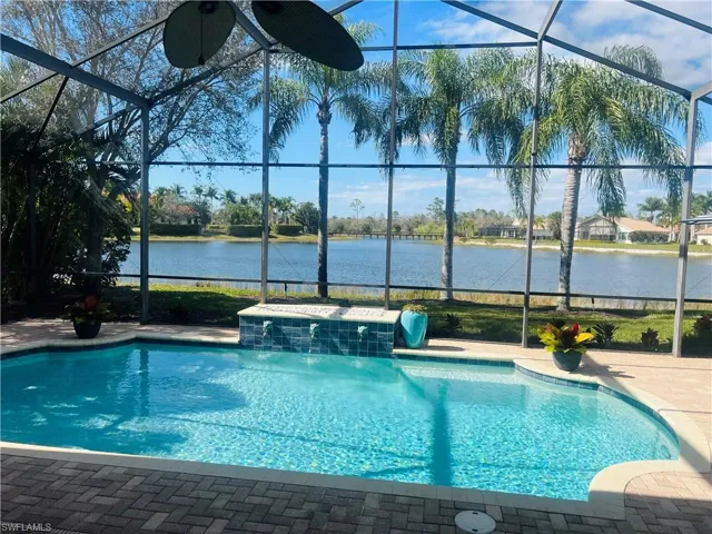 View of swimming pool featuring pool water feature and glass enclosure