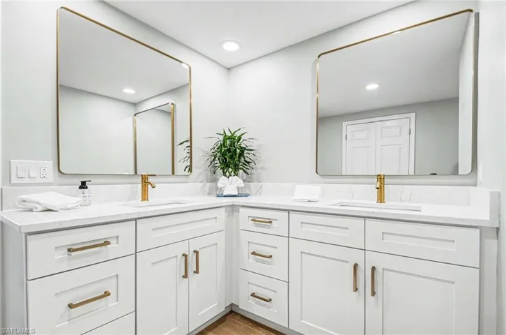 Bathroom with double vanity, light wood-style flooring, and recessed lighting
