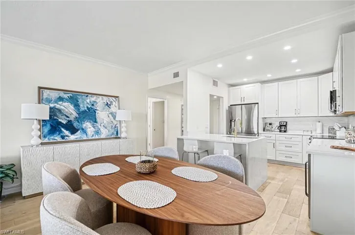 Dining space with light wood-type flooring, crown molding, and recessed lighting