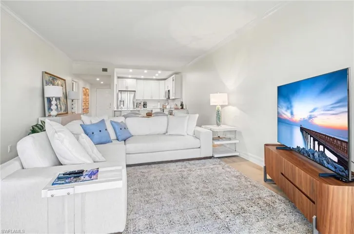 Living area with light wood-style floors and crown molding