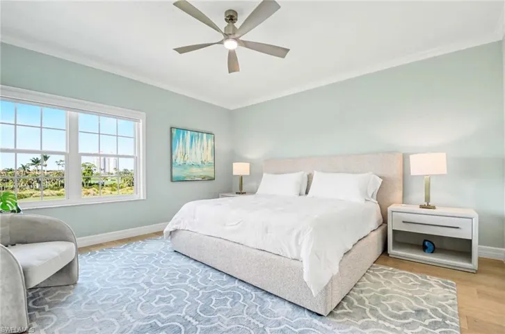 Bedroom with ornamental molding, ceiling fan, and wood finished floors