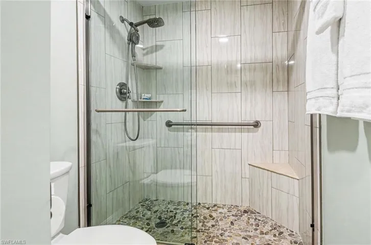 Bathroom featuring toilet and a shower stall