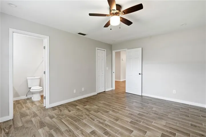 Wood-finish flooring, neutral paint palette, ceiling fan with integrated lighting, recessed lighting, and white paneled doors