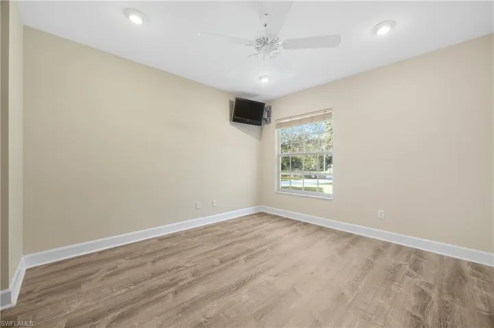 Empty room with light hardwood / wood-style flooring and ceiling fan